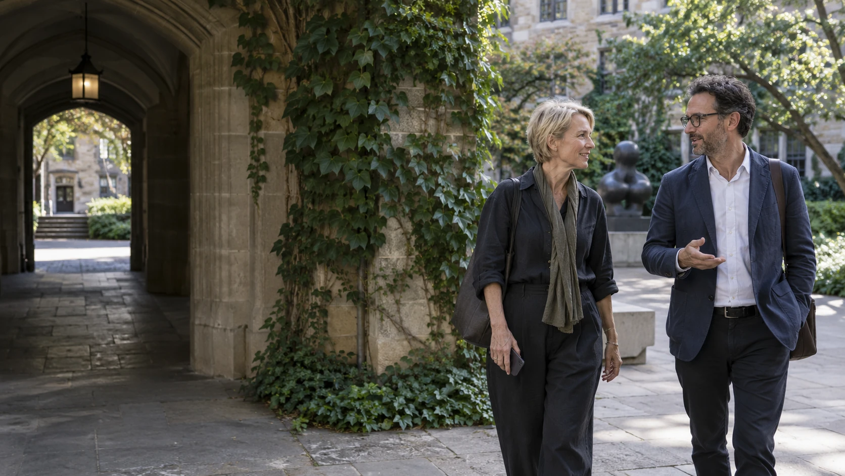 An architect and arts organizer continuing their conversation in a courtyard