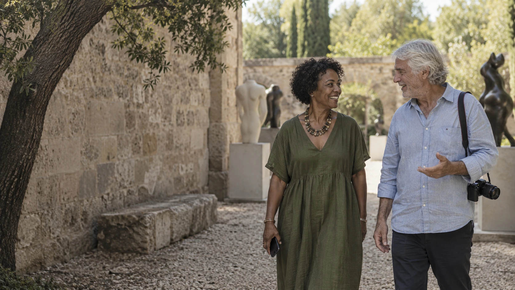 A photographer and gallery owner talking in a sculpture courtyard